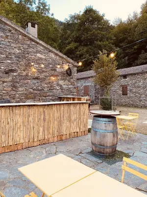 a patio with a table and a barrel at Gite d'étape Auberge Luna Piena in Santa-Reparata-di-Moriani
