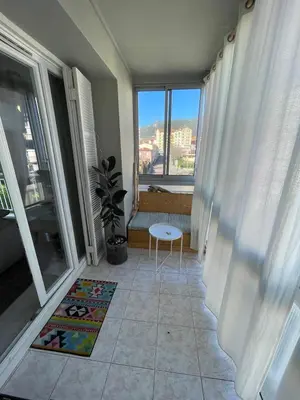 a living room with a table and a window at Loretto proche centre ville et plage in Ajaccio