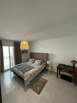 a bedroom with a bed and a table and a lamp at Loretto proche centre ville et plage in Ajaccio