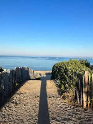 a long shadow of a fence on a beach at Loretto proche centre ville et plage in Ajaccio