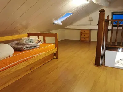 a bedroom with a wooden bed and a staircase at Casuccia Piazza di i Fiori in Penta-di-Casinca