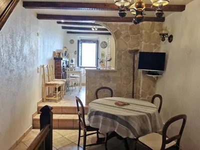 a dining room with a table and chairs and a television at Casuccia Piazza di i Fiori in Penta-di-Casinca