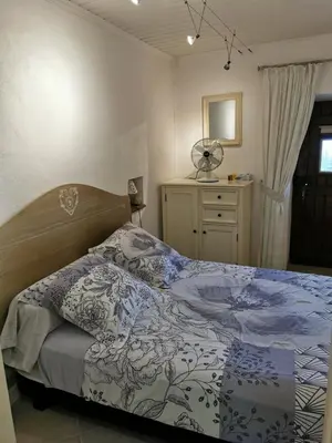 a bedroom with a bed and a dresser with a fan at Casuccia Piazza di i Fiori in Penta-di-Casinca