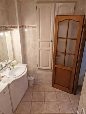 a bathroom with a sink and a toilet and a door at Casuccia Piazza di i Fiori in Penta-di-Casinca