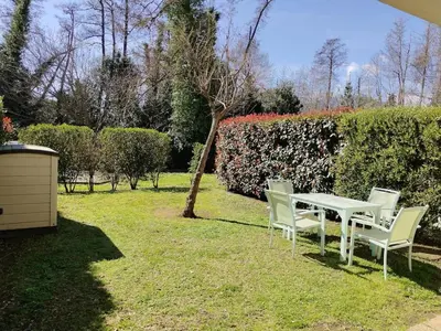 a white table and chairs in a yard at Appartement avec jardin piscine et plage 100 m in Poggio-Mezzana