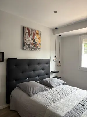 a bedroom with a large bed with a black headboard at Villa avec piscine in Alata