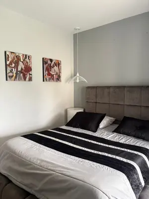 a bed in a bedroom with two pictures on the wall at Villa avec piscine in Alata