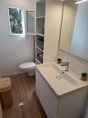 a bathroom with a sink and a toilet and a mirror at Appartement vue mer à 1min de la plage in Grosseto-Prugna