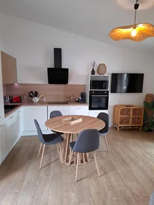 a kitchen with a wooden table and chairs at Appartement vue mer à 1min de la plage in Grosseto-Prugna