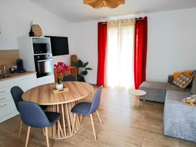 a kitchen and a living room with a table and chairs at Appartement vue mer à 1min de la plage in Grosseto-Prugna
