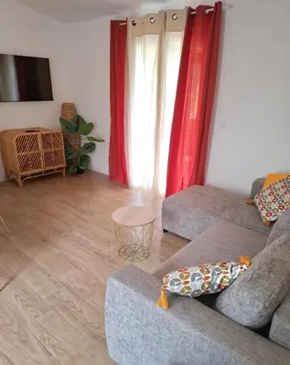 a living room with a couch and red curtains at Appartement vue mer à 1min de la plage in Grosseto-Prugna