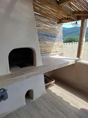 an outdoor pizza oven on top of a building at Appartement vue mer à 1min de la plage in Grosseto-Prugna