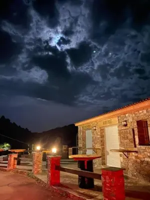 a building with a picnic table in front of it at night at Auberge chez François in Ortale