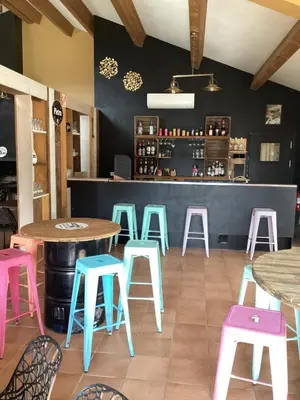 a restaurant with tables and stools in front of a counter at Auberge chez François in Ortale