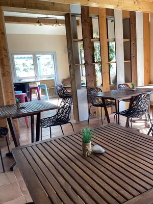 a dining room with tables and chairs and windows at Auberge chez François in Ortale