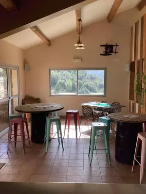 a room with tables and stools and a window at Auberge chez François in Ortale