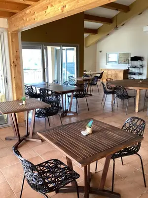a restaurant with wooden tables and chairs and windows at Auberge chez François in Ortale