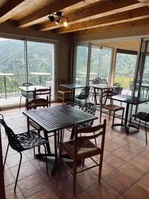 a dining room with tables and chairs and windows at Auberge chez François in Ortale