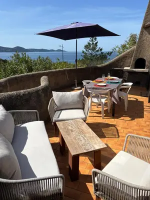 a patio with a table and chairs and an umbrella at Appartement T2 in Pietrosella