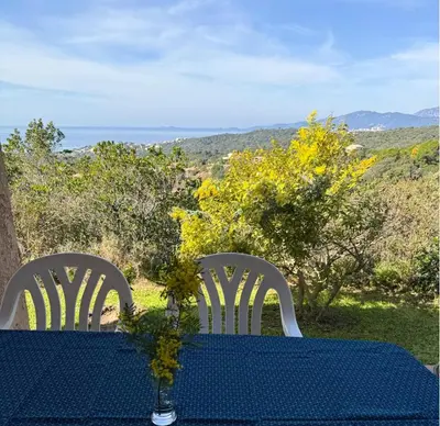 a blue table with two white chairs and a table with a view at Domaine Mare e Monti - T2 Les Mimosas in Albitreccia