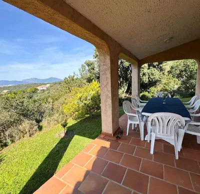 a table and chairs on a patio with a view at Domaine Mare e Monti - T2 Les Mimosas in Albitreccia