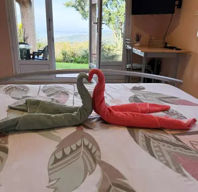 two red swans sitting on top of a bed at Domaine Mare e Monti - T2 Les Mimosas in Albitreccia