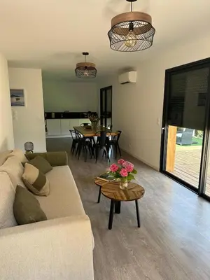 a living room with a couch and a table at Casa Juliette Maison bois in Aléria