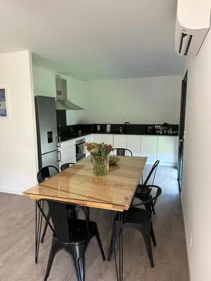 a dining room table with chairs and a vase of flowers on it at Casa Juliette Maison bois in Aléria
