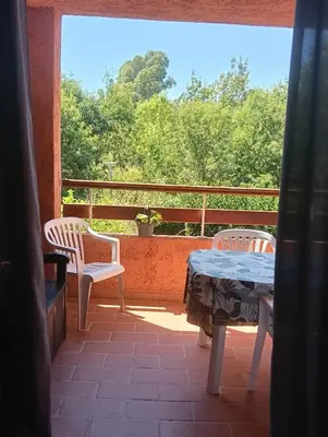 a table and chairs and a grill on a porch at LES BULLES DE MONA - Marina Corse - 2 ch - Clim - Terrasse-pieds dans leau-plage in Ghisonaccia