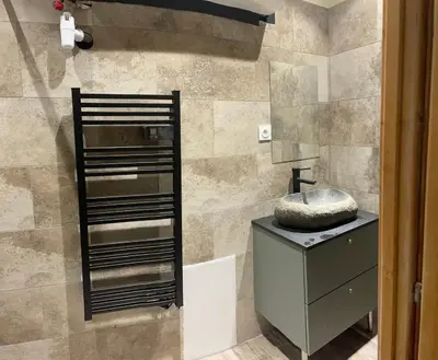 a bathroom with a sink and a stone wall at Lovely apartment in Sartène in Sartène