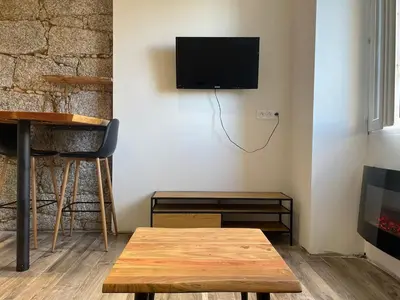 a living room with a table and a tv on a wall at Lovely apartment in Sartène in Sartène