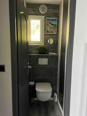 a small bathroom with a toilet and a window at Le petit mauricia in San-Nicolao