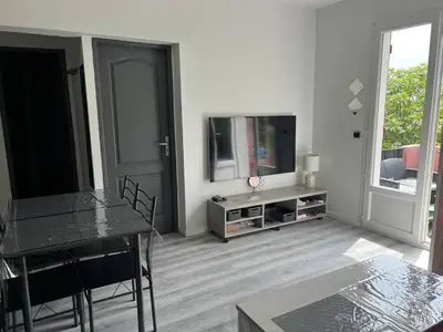 a living room with a television and a table and chairs at Le petit mauricia in San-Nicolao