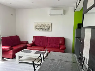 a living room with a red couch and a table at Le petit mauricia in San-Nicolao