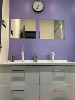 a bathroom with a sink and a clock on the wall at Le petit mauricia in San-Nicolao