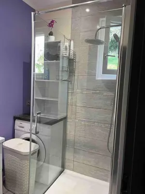 a shower with a glass door in a bathroom at Le petit mauricia in San-Nicolao