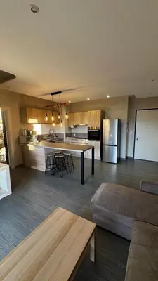a large kitchen and living room with a table and a couch at Appartemment vue mer 50m2 in Propriano