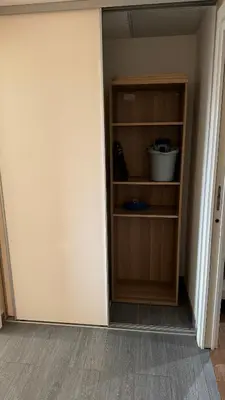 a room with a book shelf in the corner at Appartemment vue mer 50m2 in Propriano