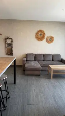 a living room with a couch and two mirrors on the wall at Appartemment vue mer 50m2 in Propriano