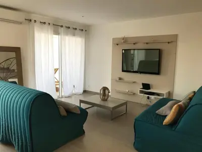 a living room with a blue couch and a tv at PDM Appartement Paese di Mare in Santa-Lucia-di-Moriani