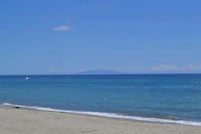 a person standing on a beach near the ocean at PDM Appartement Paese di Mare in Santa-Lucia-di-Moriani