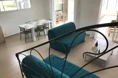 a living room with a blue couch and a table at PDM Appartement Paese di Mare in Santa-Lucia-di-Moriani