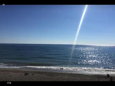 a view of the beach with a rainbow in the sky at PDM Appartement Paese di Mare in Santa-Lucia-di-Moriani