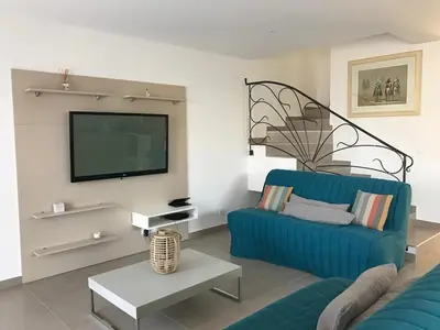 a living room with a blue couch and a tv at PDM Appartement Paese di Mare in Santa-Lucia-di-Moriani