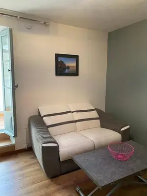 a living room with a couch and a table at OTA T2 proche rivières et plages, randonnées in Guaita