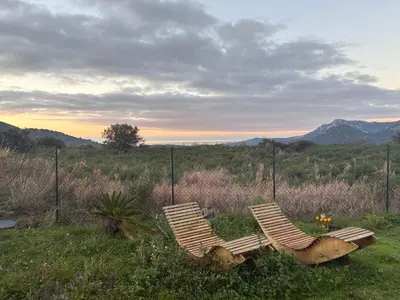 two chairs sitting in the grass in a field at T3 Baie de Calvi jardin panoramique vue mer in Calenzana