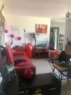 a living room with a red couch and a table at T3 Baie de Calvi jardin panoramique vue mer in Calenzana