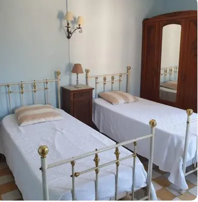 a bedroom with two beds and a mirror at Appartement Caprunale Rivière & Maquis in Manso
