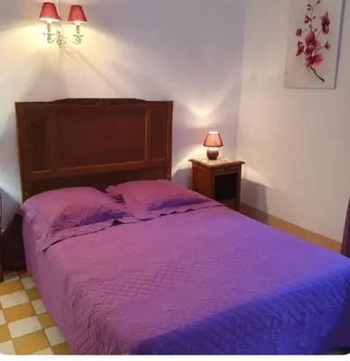 a bedroom with a purple bed with two pillows at Appartement Caprunale Rivière & Maquis in Manso