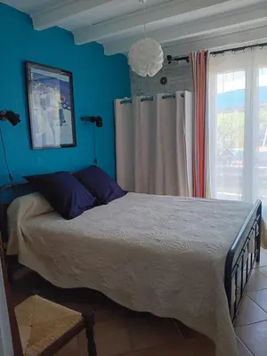 a bedroom with a bed with blue walls and a window at Corse-San Giuliano-maison- 2 mn de la plage in San-Giuliano